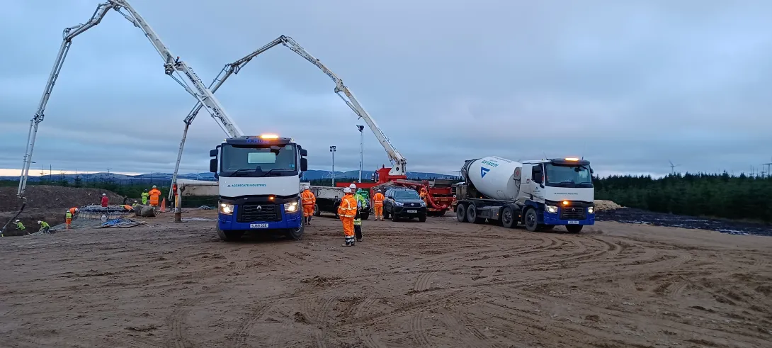 Two Aggregate Industries Concrete Mixing Trucks pump readymix concrete onto the site of Longhill Burn Wind Turbine project in Scotland