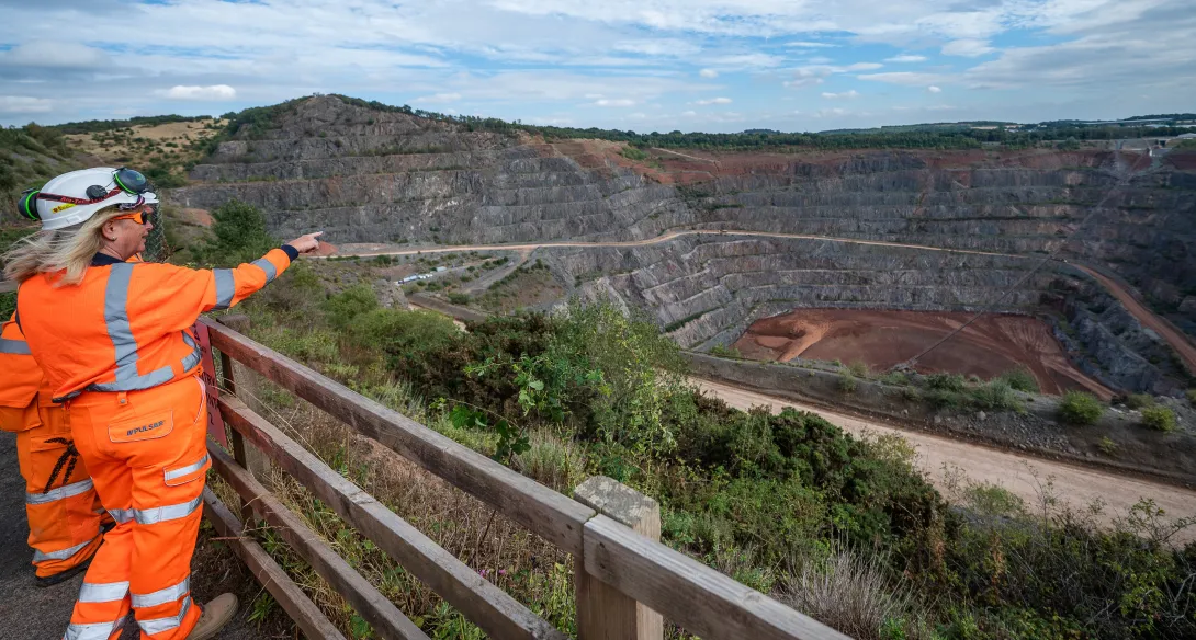 Two Aggregate Industries workers look out over the old Bardon Hill quarry and the Dopplemayr Ropecon system which carries overburden via a three mile long conveyor system.