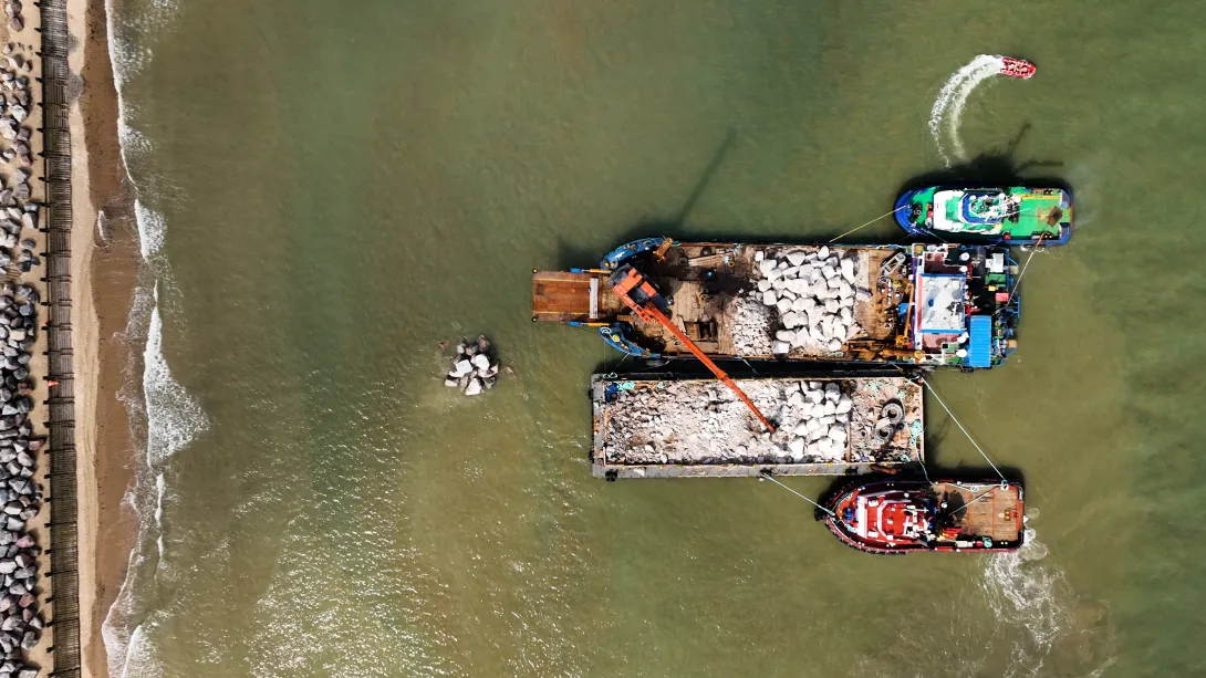 Rockarmour aggregates from Aggregate Industries' Glensanda Quarry being transported by ship and barge to be used for coastal defences at Cromer in North Norfolk