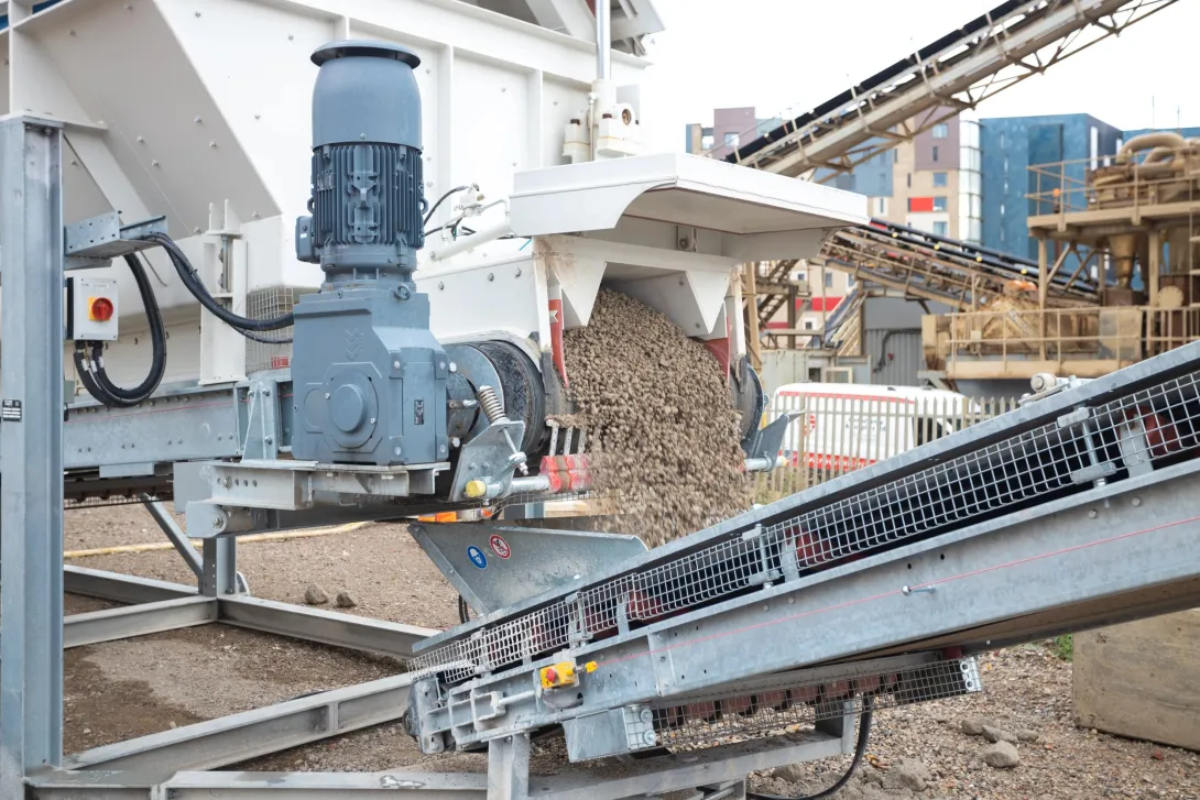 Carbonated material exiting the neustark machinery onto a conveyor belt.