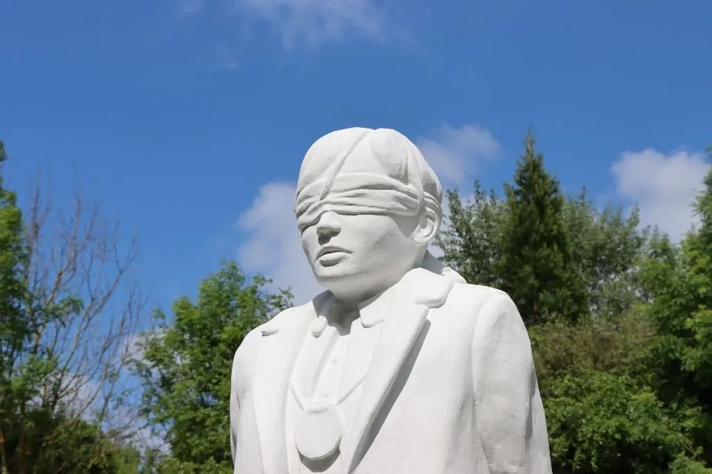 A statue depicting a blindfolder solider at The Shot at Dawn Memorial at the National Memorial Arboretum