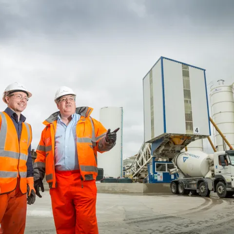 Plant manager infront of readymix concrete factory with readymix truck