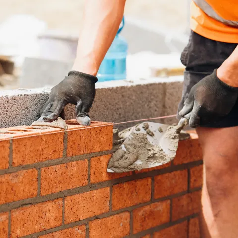 Man laying bricks on a wall